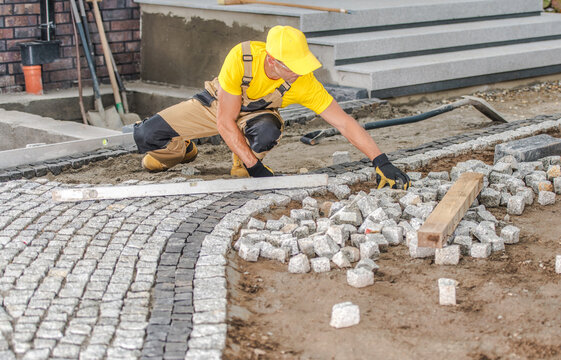 Construction Worker Laying Paving Stones Walkway