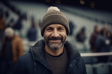 Fototapeta premium Handsome bearded man in a hat and coat smiling at the camera
