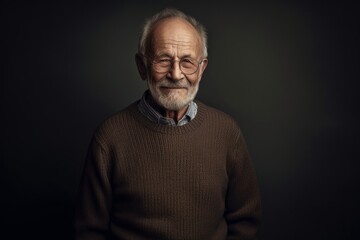 Portrait of an old man with grey hair in a brown sweater.