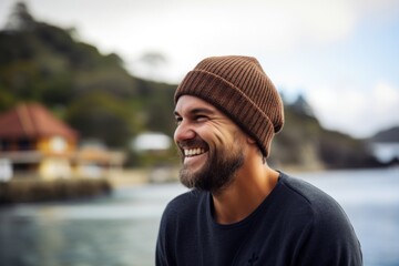 Portrait of a smiling young man wearing a hat at the beach