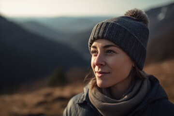 Portrait of a beautiful girl in a hat and scarf in the mountains