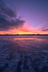 Purple sunset on winter frozen water