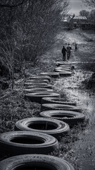 A path made of old tires with people walking in the distance