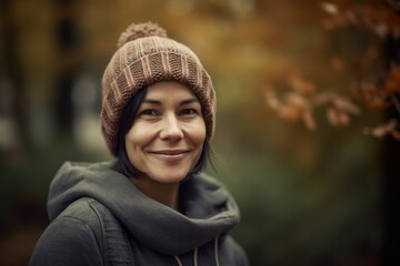 Portrait of a beautiful young woman in a knitted hat in autumn park