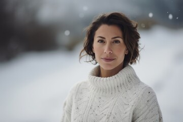 Portrait of a beautiful young woman in a white sweater on the background of a winter landscape