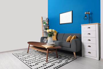 Stylish living room interior with comfortable grey sofa and coffee table