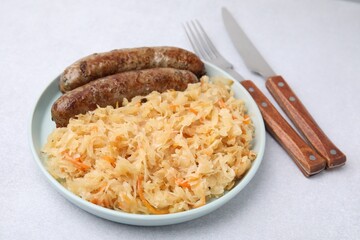 Plate with sauerkraut and sausages on light table