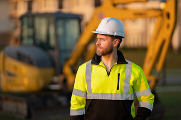 Worker in helmet on site construction. Excavator bulldozer male worker. Construction driver worker...