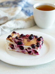 Homemade healthy baked italian dessert cottage cheese lasagna with cherry on a white plate on a white wooden background, Closeup. Vertical