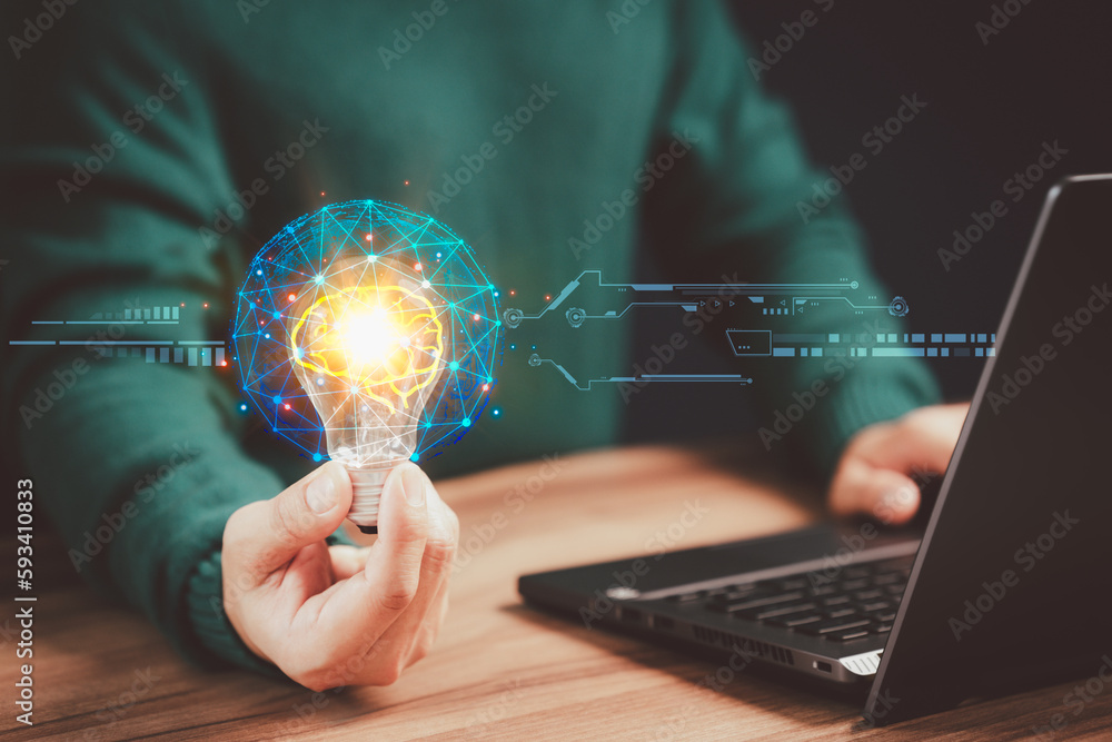 Aufkleber businessman holding a light bulb while working on the computer to think and create new ideas with te