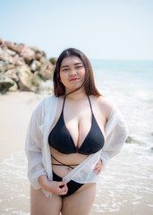 Portrait young woman asian chubby fat cute beautiful one person in bikini black sexy frontview tropical sea beach white sand clean and blue sky background calm nature ocean wave water travel fun happy