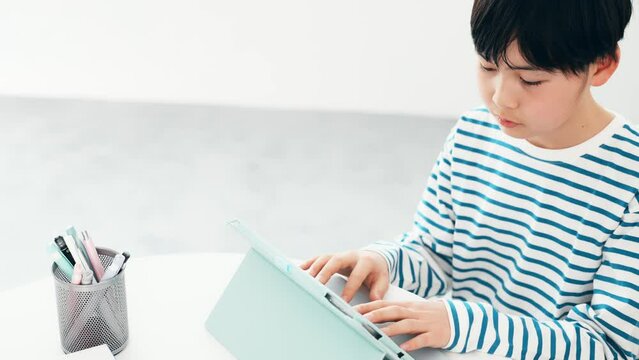 タブレットの画面をタッチする男の子