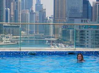 young beautiful woman walking along Dubai Marina in Dubai, UAE