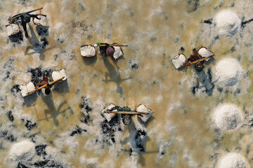  Aerial view of worker harvesting salt in salt field at Ban Laem-Thailand	