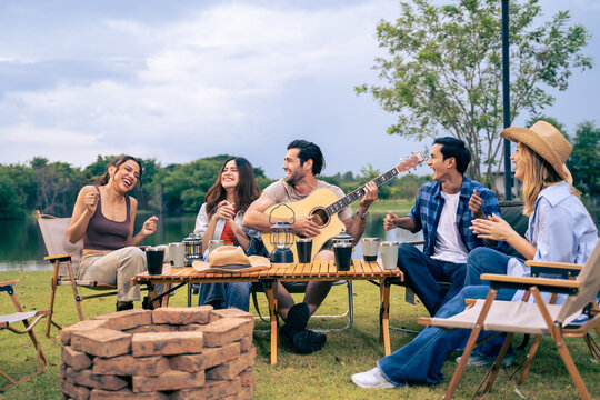 Group of diverse friend having outdoors camping party together in tent. 