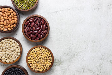 top view of red kidney beans, peanuts, soybean and white kidney beans in bowls with copy space