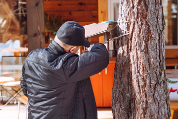 A man puts food in a bird feeder