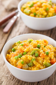 Charquican traditional Chilean dish, vegetarian version made of lightly mashed and mixed potatoes, pumpkin, onion, carrots, peas, corn and green beans (Selective Focus in the middle of the first dish)
