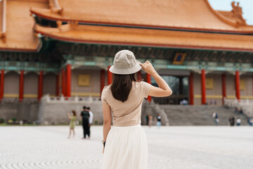 woman traveler visiting in Taiwan, Tourist with hat sightseeing in National Chiang Kai shek Memorial or Hall Freedom Square, Taipei City. landmark and popular attractions. Asia Travel concept