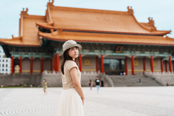 woman traveler visiting in Taiwan, Tourist with hat sightseeing in National Chiang Kai shek Memorial or Hall Freedom Square, Taipei City. landmark and popular attractions. Asia Travel concept