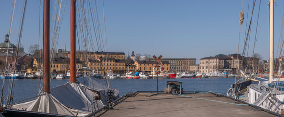 Old sail ship moored at a pier, background the bay Nybroviken with offices and archipelago...