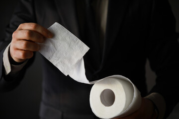 Rich Businessman paying in Toilet Paper, copy space. Toilet papers is the new currency