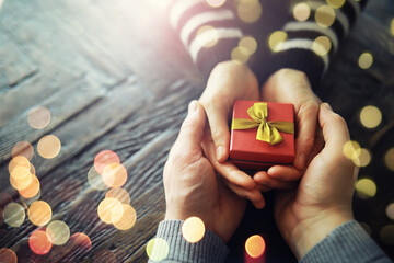 Male female hands holding gift box for birthday on wooden background. Fathers day valentine day, Christmas, New Year. Congratulations background.