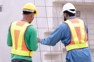 Engineers and construction workers walk on site at a construction site.