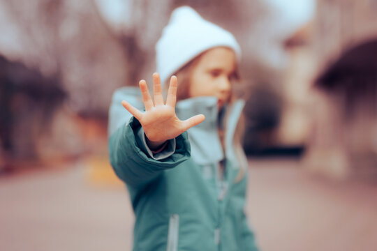 Unhappy Preschool Little Girl Making a Stop Bullying Gesture. Desperate bullied child defending herself making halt sign
