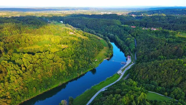 River Kupa next to the highway between dense forests in the sunlight