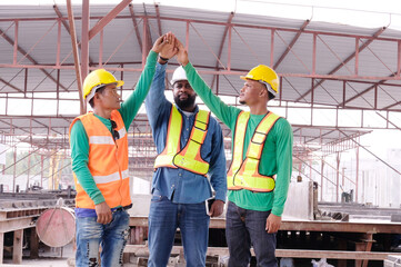 Engineers and construction workers handshake teamwork.