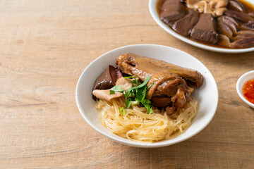 dried noodles with braised duck in white bowl