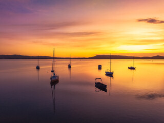 Aerial sunrise waterscape with boats and high cloud