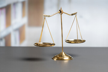 Shiny golden balanced scale in court library background as concept justice and fairness legal...