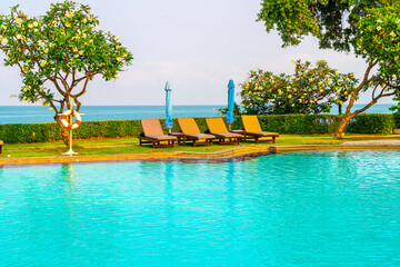 chair pool  or bed pool and umbrella around swimming pool with sea background