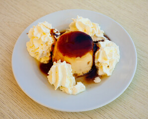 Image of tasty dessert cream flan served with butter cream at plate