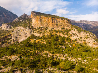 Fototapeta na wymiar Scenic view of crag with rock hewn tombs towering over ancient Lycian city of Pinara, Mugla Province, Turkey