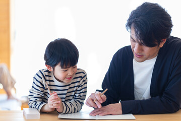 勉強をする男の子と教える父親
