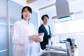 Obraz premium キッチンに立つ夫婦