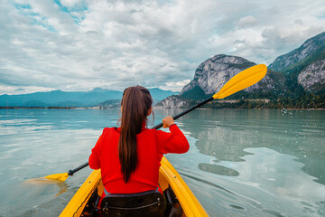 Woman kayaking in Squamish paddling in kayak in Howe Sound a fjord surrounded by mountains. People living healthy active outdoor lifestyle in British Columbia, Canada