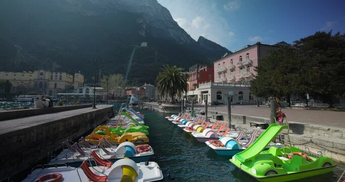 Docked rental pedalo boats in Riva del Garda on a sunny summer day