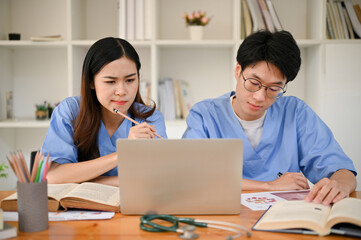 Focused Asian medical students are researching medical information and studying together