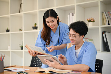 Two smart young Asian medical students are discussing and researching medical papers
