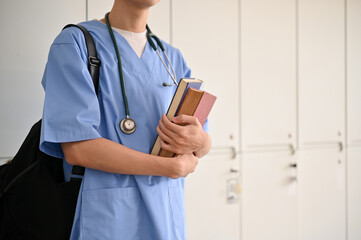 Cropped image, An Asian male medical student in a uniform with his medical books and backpack