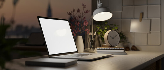 Close-up side view image of modern workspace at night with laptop mockup
