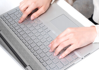 Fototapeta na wymiar ノートパソコンのキーボードを打つ若い女性の手