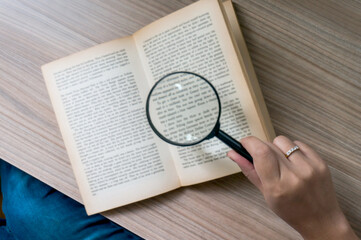 Books and a magnifier Research concept. Magnification glass over a opened book.