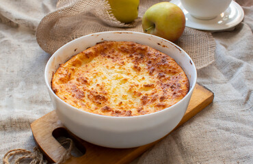 Breakfast. Freshly baked casserole, apples and a cup of coffee on the table.