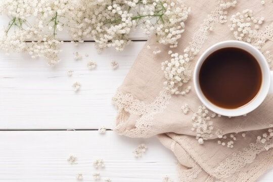 Refreshing spring vibes! Top view photo of a cup of coffee, gypsophila flowers, and a beige scarf on a light wooden background with empty space for text or logo.