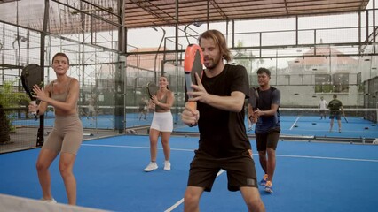 A lot of people sport play practice. Coach teach person serve big tennis ball. Teacher show padel exercise. Team players training racket game. Trainer class workout. Fun tutor guy prepare fit lesson.